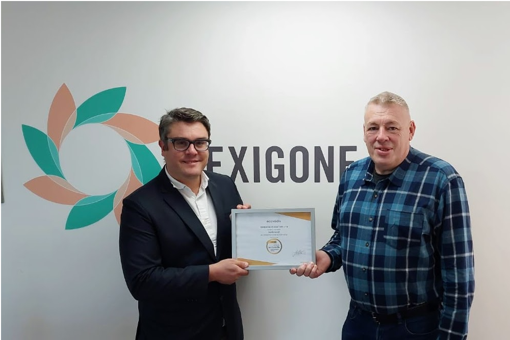 Two men holds the EcoVadis award in front of the Hexigone logo