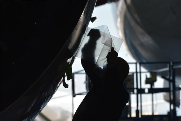An operator applying the AeroSHARK film on a Boeing aircraft