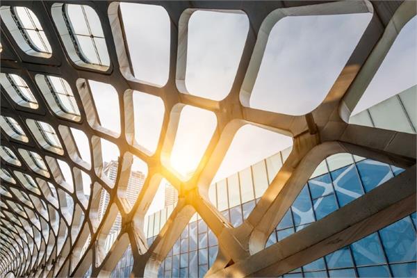 A metal and glass structure at sunset