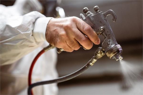 Photo of an operator wjile coating with a spray gun