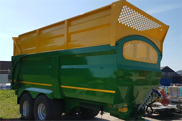 An earth-moving machine painted green and yellow with the new coatings of HMG