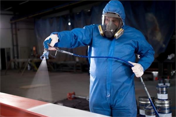 An operator in a blue uniform applies the Hempafire Pro 400 coating of Hempel on a steel structure