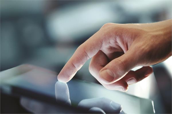 A white man's hand touching the display of a tablet