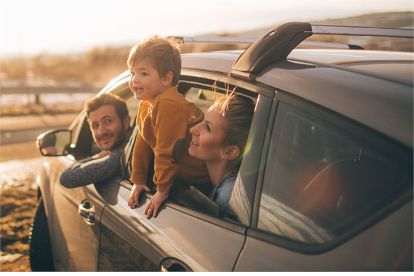 A family looking at the sunset from a car
