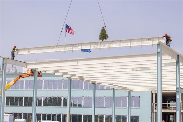 Construction workers posing the final beam of the new headquarters of Sherwin-Williams